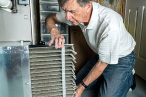 image of a homeowner replacing a furnace filter