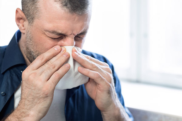 image of a man sneezing due to high allergens in house and hvac filter