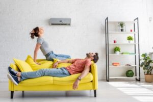 man and woman feeling warm in front of ductless AC blowing warm air