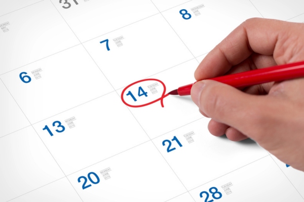 homeowner encircling a date on a calendar for HVAC maintenance schedule