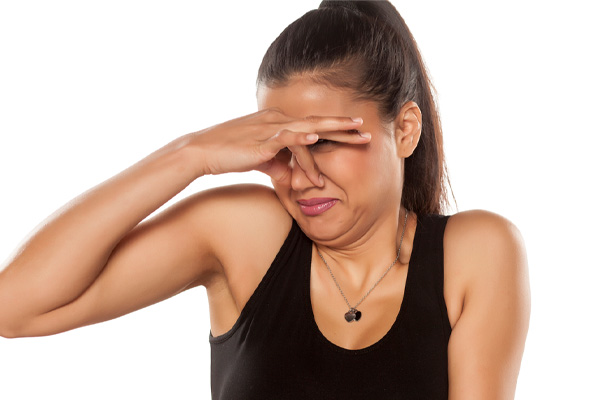 woman plugging nose from smelly air conditioner