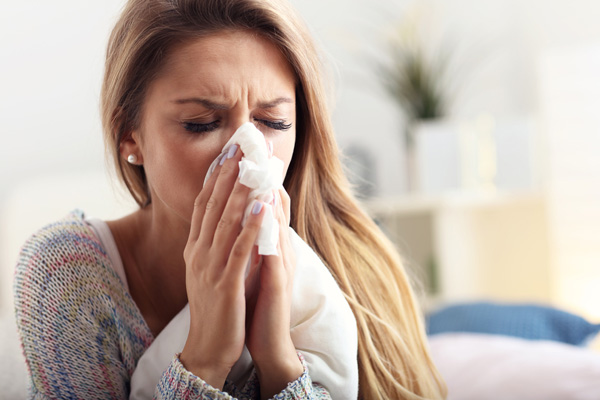 woman sneezing due to poor indoor air quality