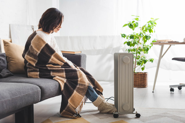 woman using space heater incorrectly