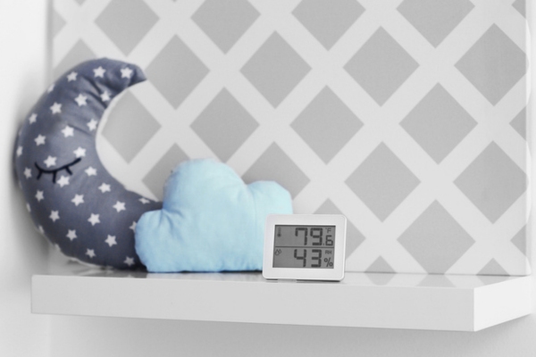 hygrometer on a shelf beside moon and clouds pillow depicting balancing humidity