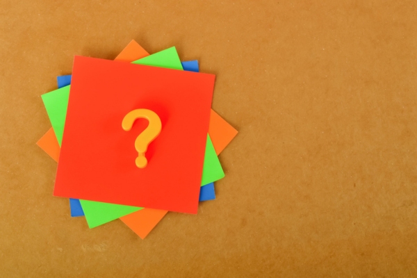question mark on a stack of colored papers depicting common questions about air conditioner tune-up