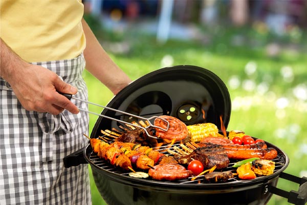 image of a homeowner grilling outside to prevent heat inside home