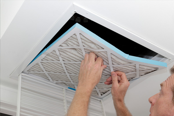 image of a man replacing home air filter