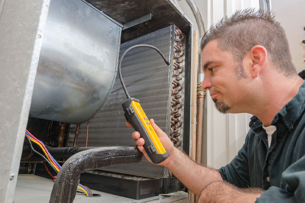 image of an hvac contractor checking air conditioner refrigerant levels