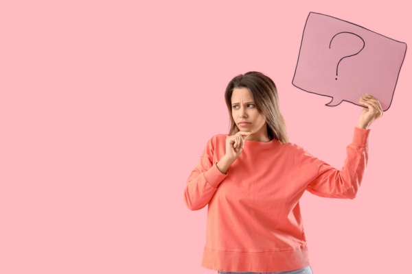 woman holding speech bubble cutout with question mark depicting Why Homeowners Think They Should Cover AC