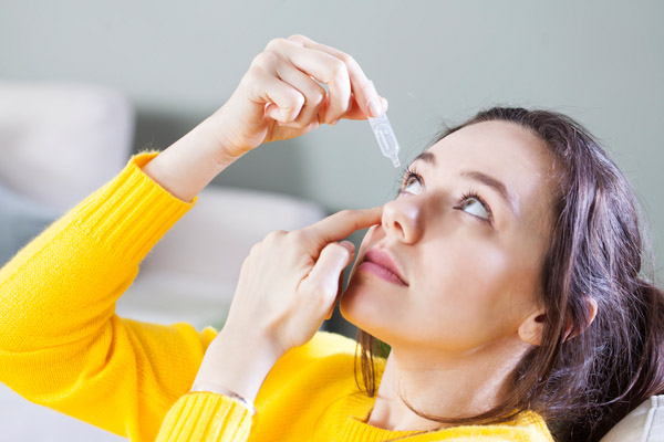 image of homeowner putting artificial tears in eyes depicting poor air quality in winter