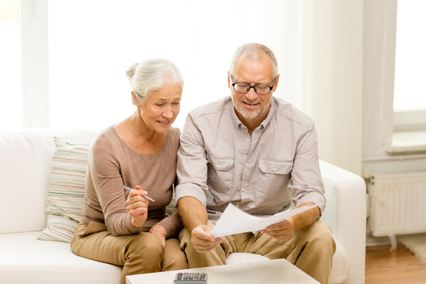 Smiling couple calculating energy savings with a new efficient oil heating system