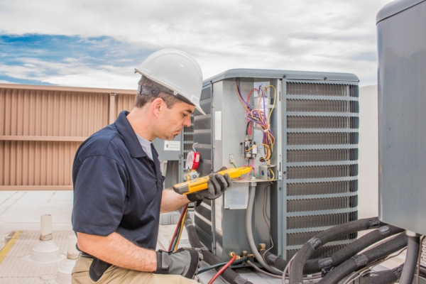 HVAC technician attending to outdoor AC unit
