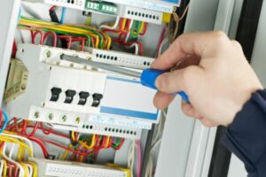 electrician repairing circuit breaker box due to air conditioner tripping circuit breaker
