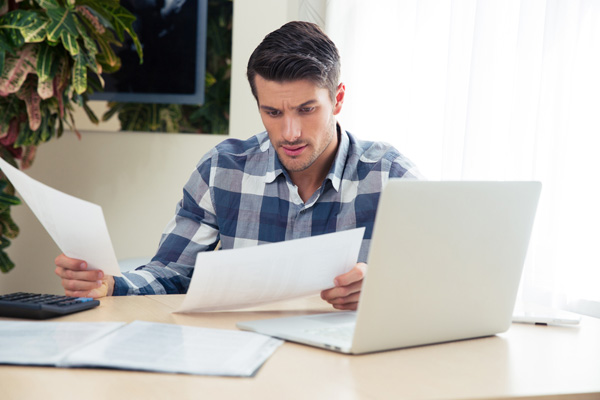 image of a homeowner reviewing energy bills after summer and air conditioning