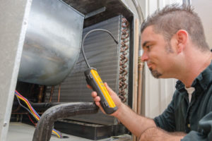 image of an hvac contractor examining an overcharged air conditioning unit