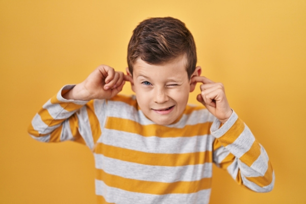 kid covering ears with fingers depicting noisy window AC