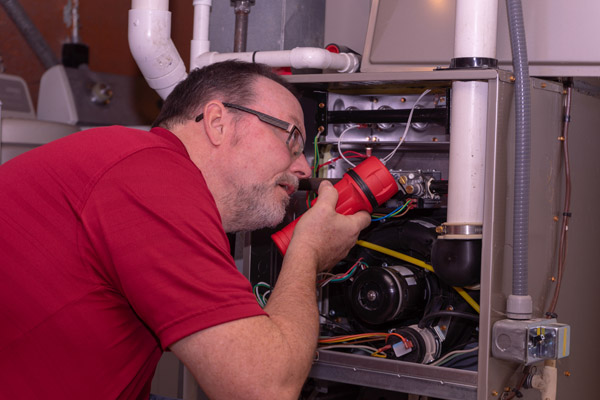 image of a furnace technician repairing hvac system