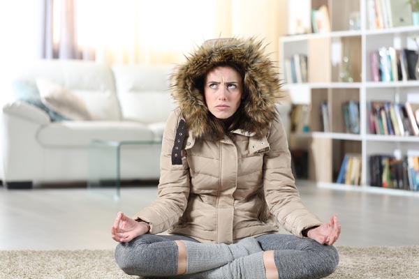 image of a homeowner feeling chilly due to boiler heating problems