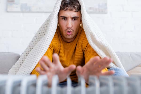 image of a homeowner in front of radiator depicting boiler problems