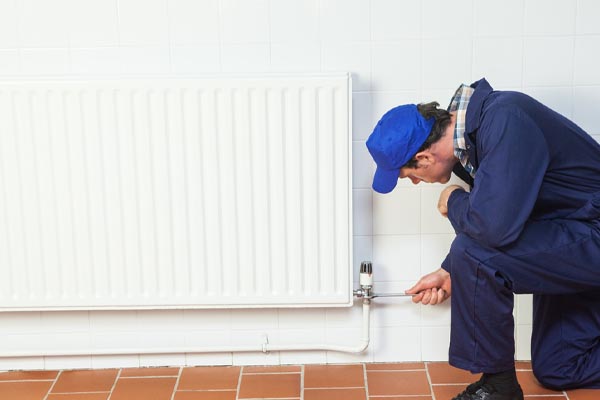 image of an hvac contractor repairing a radiator