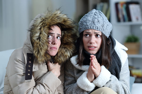 image of a homeowner feeling chilly due to undersized furnace