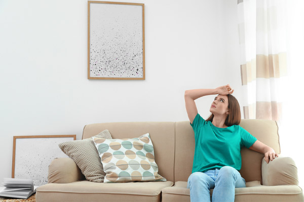 image of a homeowner feeling hot and uncomfortable due to an ac unit not blowing cold air