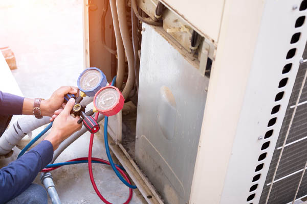image of an hvac technician cleaning air conditioner condensing unit due to rust