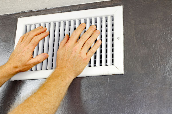 image of hvac air vent and hands depicting poor hvac airlfow