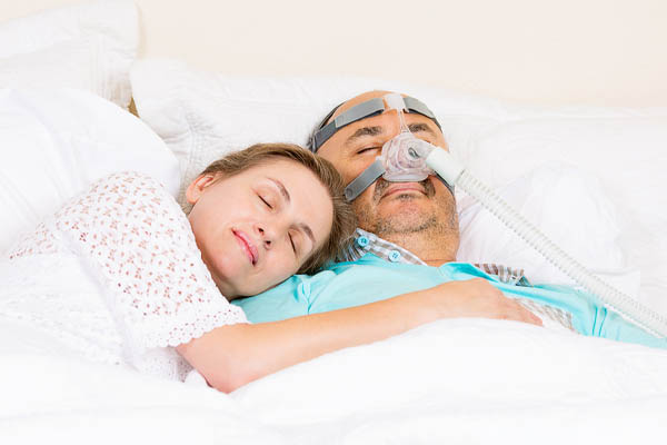 image of an elderly couple sleeping with cpap machine and backup generator