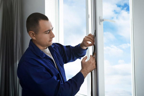 homeowner applying weatherstripping for home efficiency