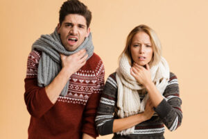 image of a couple layering up due to a heating problem at home