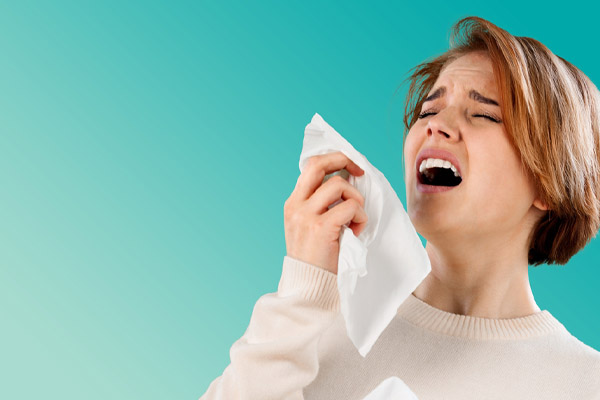 person sneezing due to poor indoor air quality symptoms
