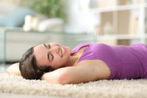woman resting lying on a carpet at home depiting hvac air quality