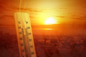 summer sun and thermometer depicting warm temperature