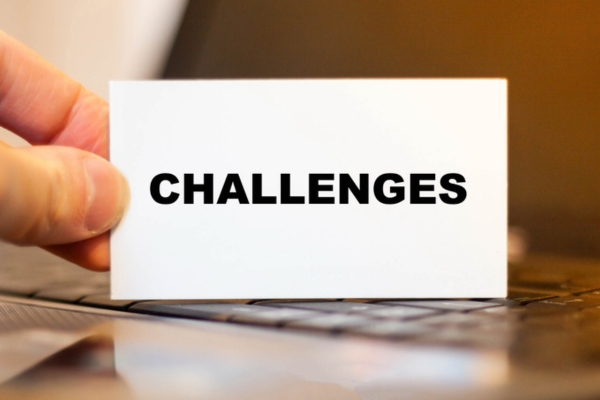 challenges written on a card held by a man's hand depicting air conditioner installation