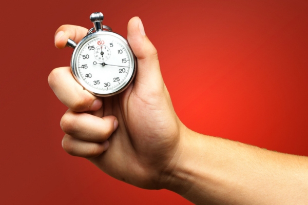 closeup of a hand holding a stopwatch depicting installation time for air conditioning units