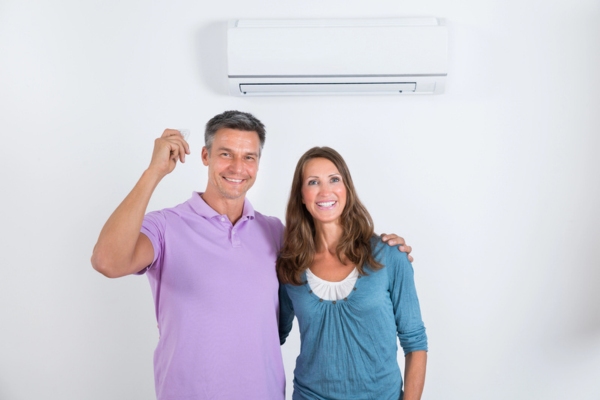 couple standing in front of ductless AC
