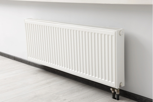 Modern radiator on white wall in room