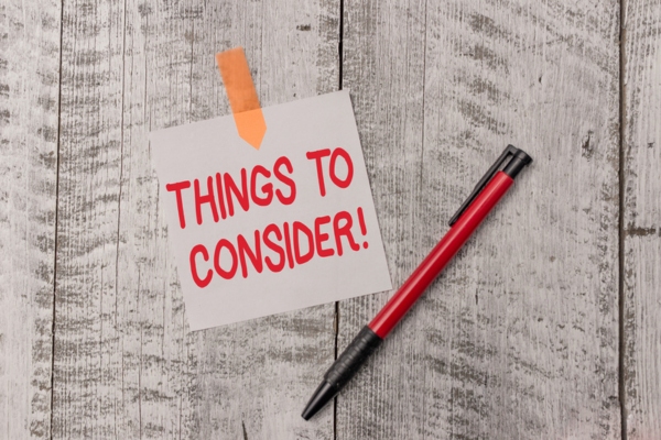 things to consider written on a sticky note on a table depicting Deciding Between Forced Air and Hydronic Heating