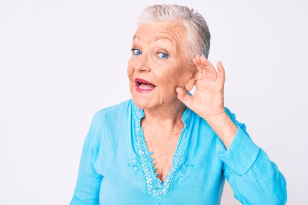 senior woman with hand over ear listening to furnace sounds