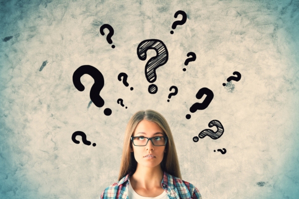 woman wearing glasses looking up with doodles of question mark above her head depicting Best Standby Generator FAQs