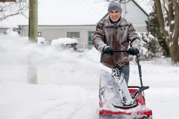 man using snow blower to Safeguard Your Backup Generator From Heavy Snow