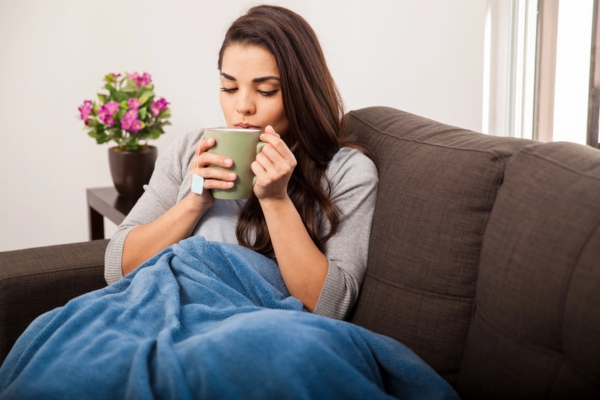woman having hot tea on the couch depicting Winter-Ready Protection