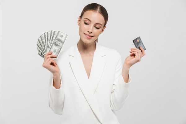 woman holding cash and card on each hand depicting Affordable Ways to Manage Heating Oil Payments