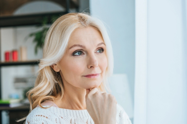 woman standing and thinking at home depicting Selecting the Best Air Conditioning System