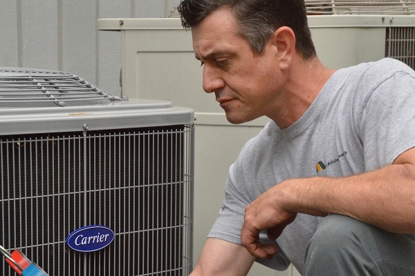 McAllister Energy HVAC technician preparing air conditioner for summer use